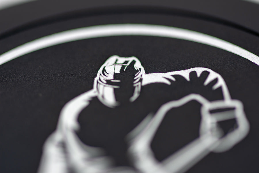 Nahaufnahme der präzisen Lasergravur « Powerplay « auf einer runden Snusdose aus gebürstetem Aluminium, feine Linien und hochwertige Verarbeitung.