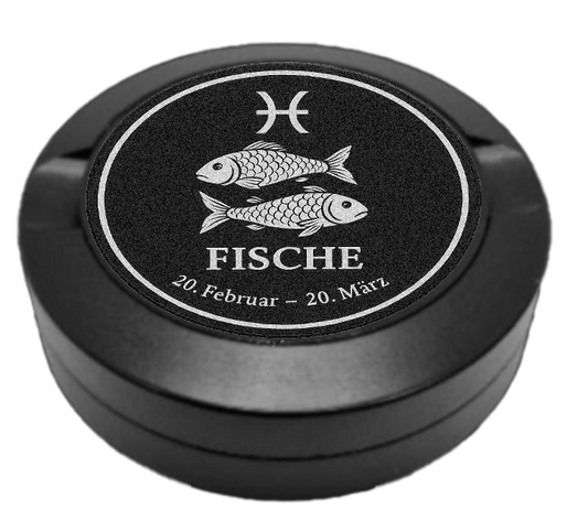 Dreiteilige Snusdose in Schwarz mit eingraviertem Sternzeichen - Motiv Fisch auf dem Deckel, stilvoll arrangiert auf einem dunklen Hintergrund.