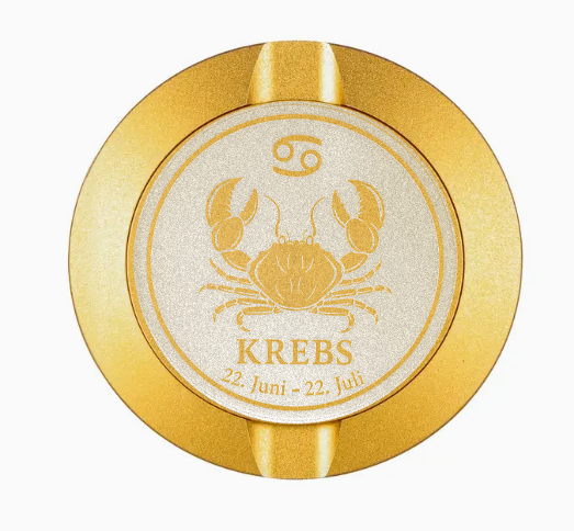 Dreiteilige Snusdose in Gold mit eingraviertem Sternzeichen - Motiv Krebs auf dem Deckel, stilvoll arrangiert auf einem dunklen Hintergrund.