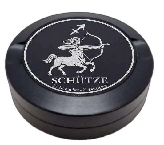 Dreiteilige Snusdose in Schwarz mit eingraviertem Sternzeichen - Motiv Schütze auf dem Deckel, stilvoll arrangiert auf einem dunklen Hintergrund.