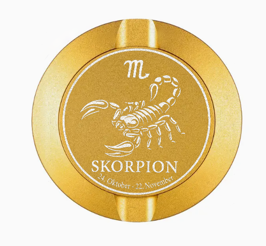 Dreiteilige Snusdose in Gold mit eingraviertem Sternzeichen - Motiv Skorpion auf dem Deckel, stilvoll arrangiert auf einem dunklen Hintergrund.