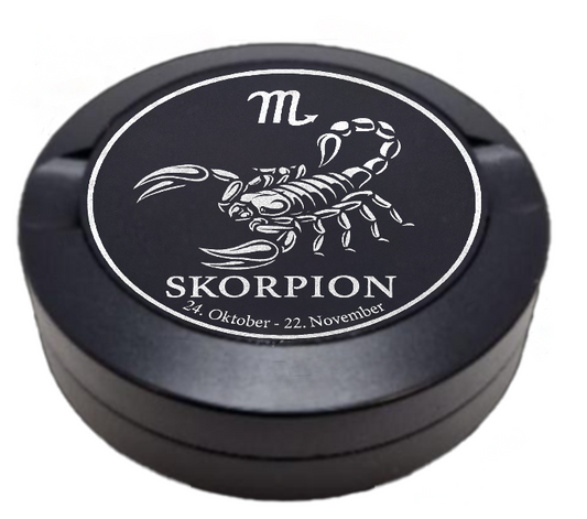 Dreiteilige Snusdose in Schwarz mit eingraviertem Sternzeichen - Motiv Skorpion auf dem Deckel, stilvoll arrangiert auf einem dunklen Hintergrund.