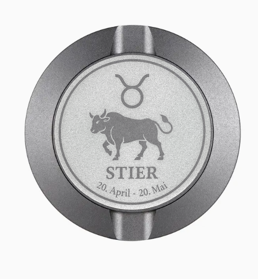 Dreiteilige Snusdose in Grau mit eingraviertem Sternzeichen - Motiv Stier auf dem Deckel, stilvoll arrangiert auf einem dunklen Hintergrund.