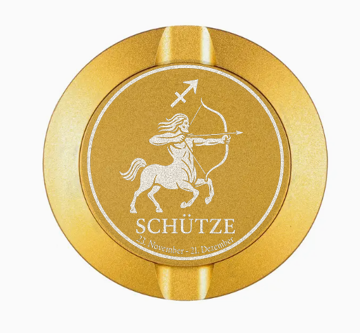 Dreiteilige Snusdose in Gold mit eingraviertem Sternzeichen - Motiv Schütze auf dem Deckel, stilvoll arrangiert auf einem dunklen Hintergrund.