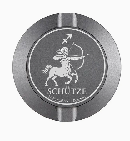 Dreiteilige Snusdose in Grau mit eingraviertem Sternzeichen - Motiv Schütze auf dem Deckel, stilvoll arrangiert auf einem dunklen Hintergrund.