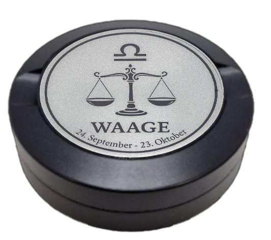 Dreiteilige Snusdose in Schwarz mit eingraviertem Sternzeichen - Motiv Waage auf dem Deckel, stilvoll arrangiert auf einem dunklen Hintergrund.