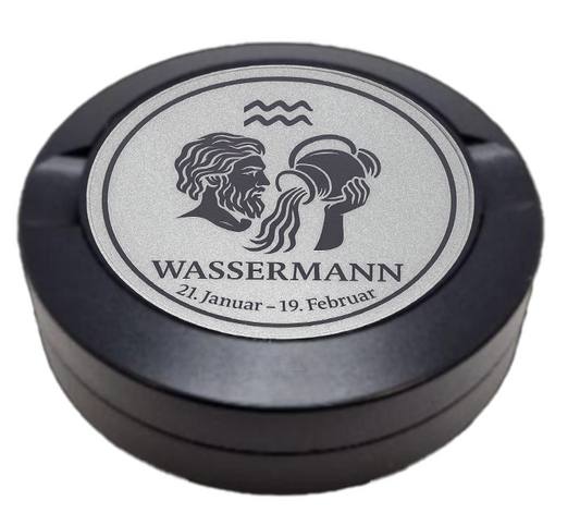 Dreiteilige Snusdose in Schwarz mit eingraviertem Sternzeichen - Motiv Wassermann auf dem Deckel, stilvoll arrangiert auf einem dunklen Hintergrund.