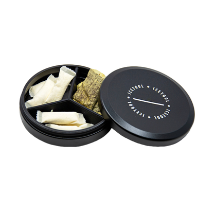 Geöffnete, gefüllte Icetool Snusdose in schwarz, Snusinhalt sichtbar.